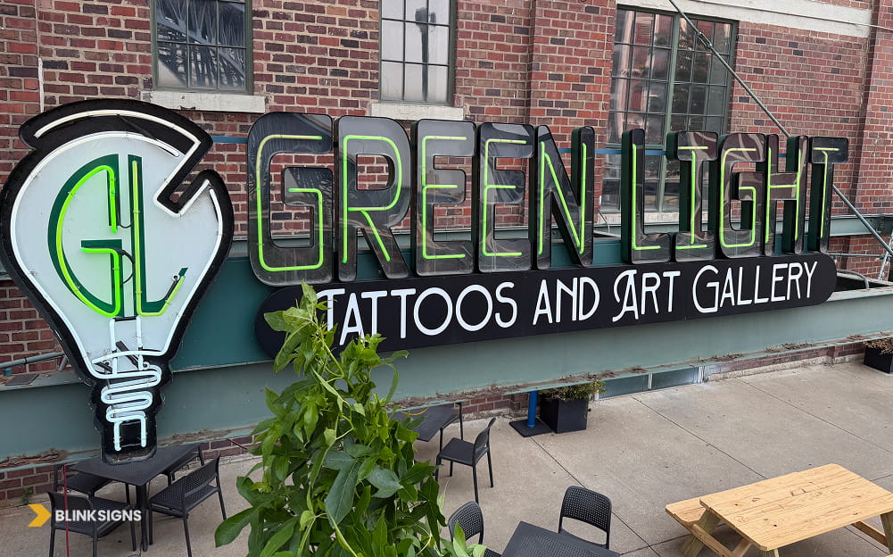 Vintage-style neon Green Light Tattoos and Art Gallery custom storefront sign mounted against an exterior brick wall.