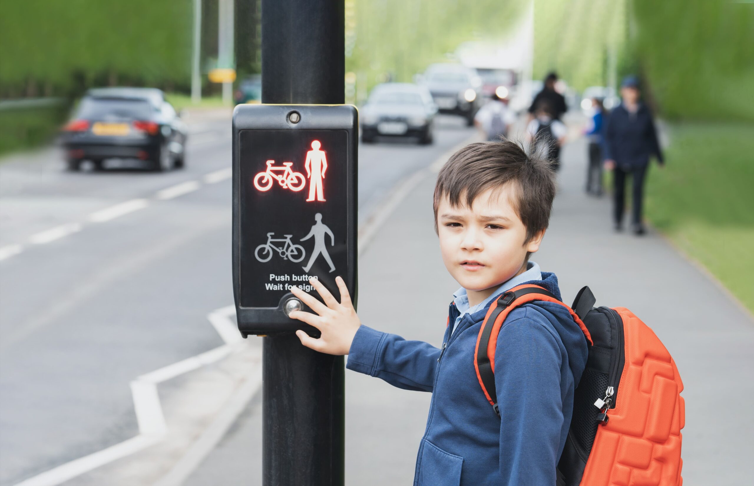 School kid pressing traffic light button