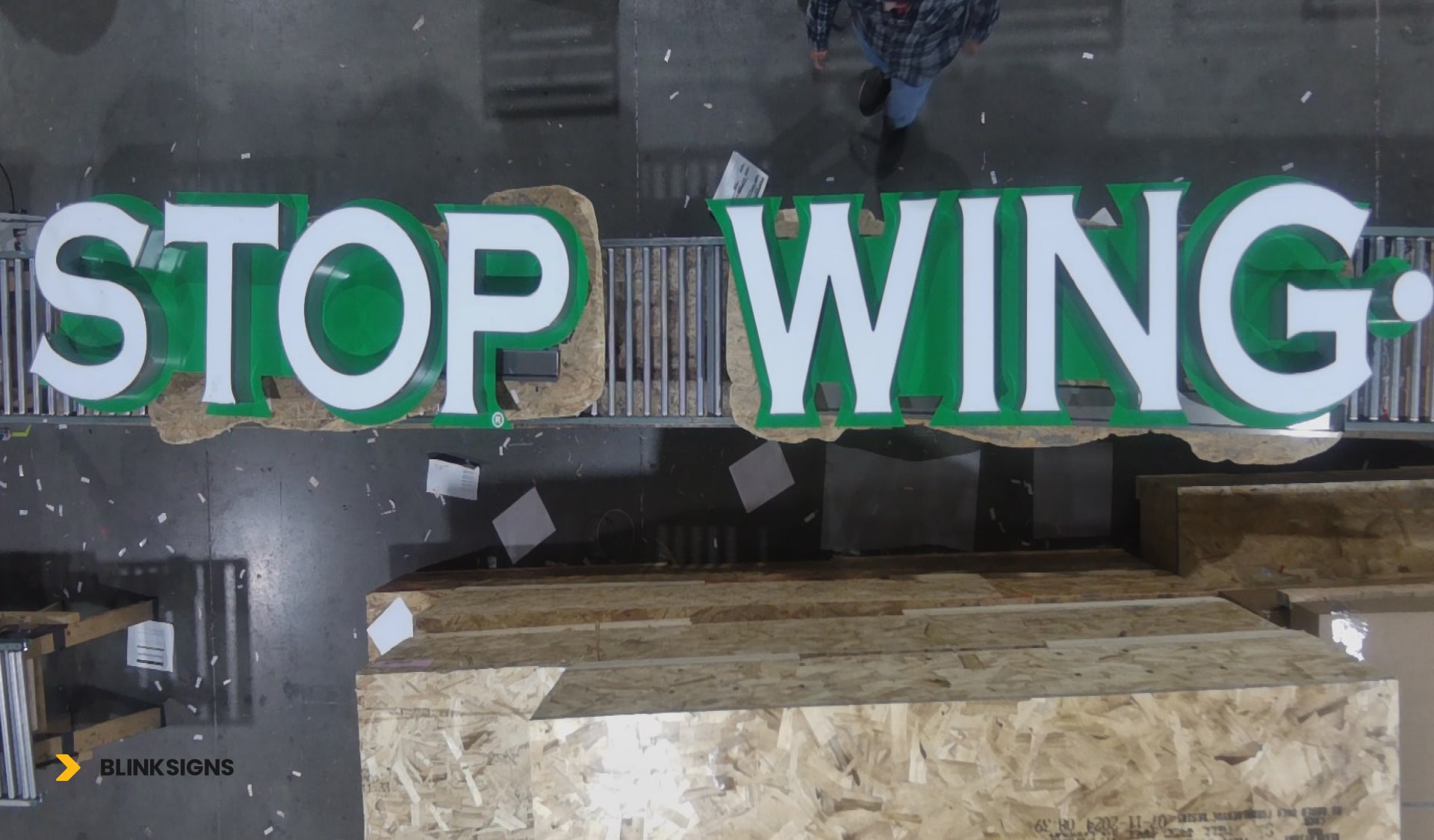 A stop wing sign positioned in the middle of a warehouse within a production facility.