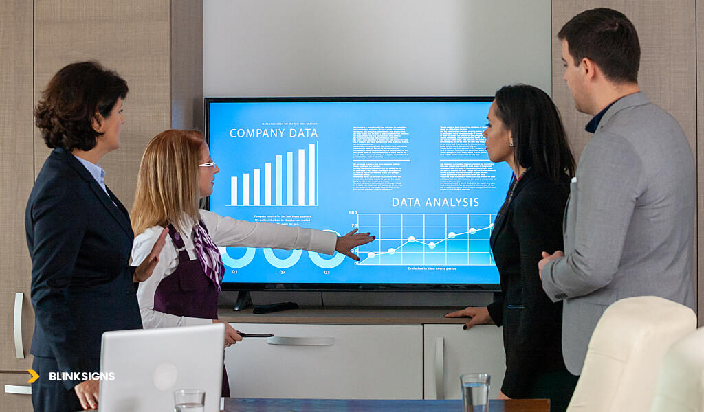 AI & Data-Driven Signage: How Smart Signs Improve Customer Experience 5 group of professionals discussing company data analytics