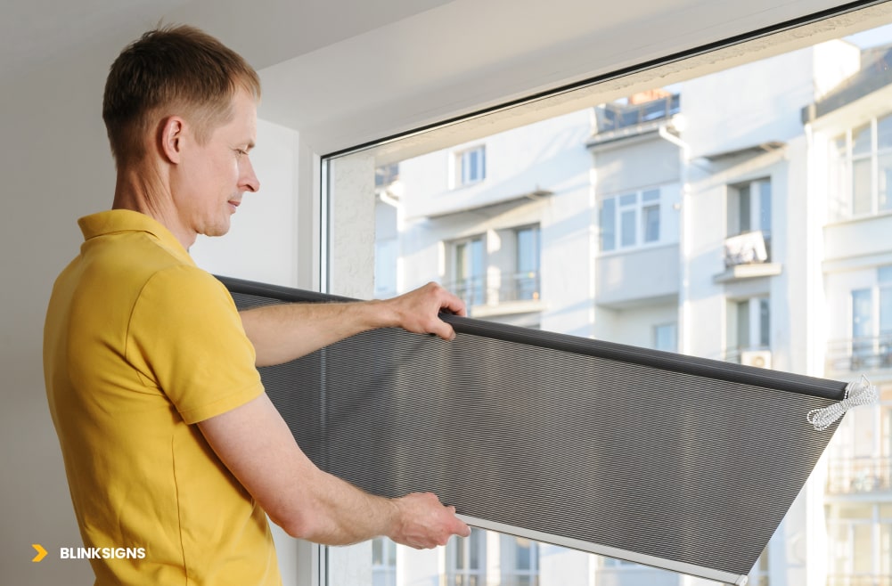person installing a security film on window glass