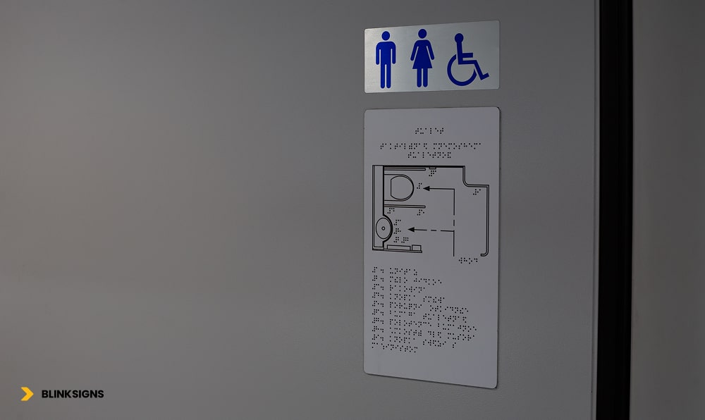 Wayfinding Accessibility: Designing Inclusive Navigation Systems for All Users 2 Accessible Sign with toilet diagram in braille text on wall