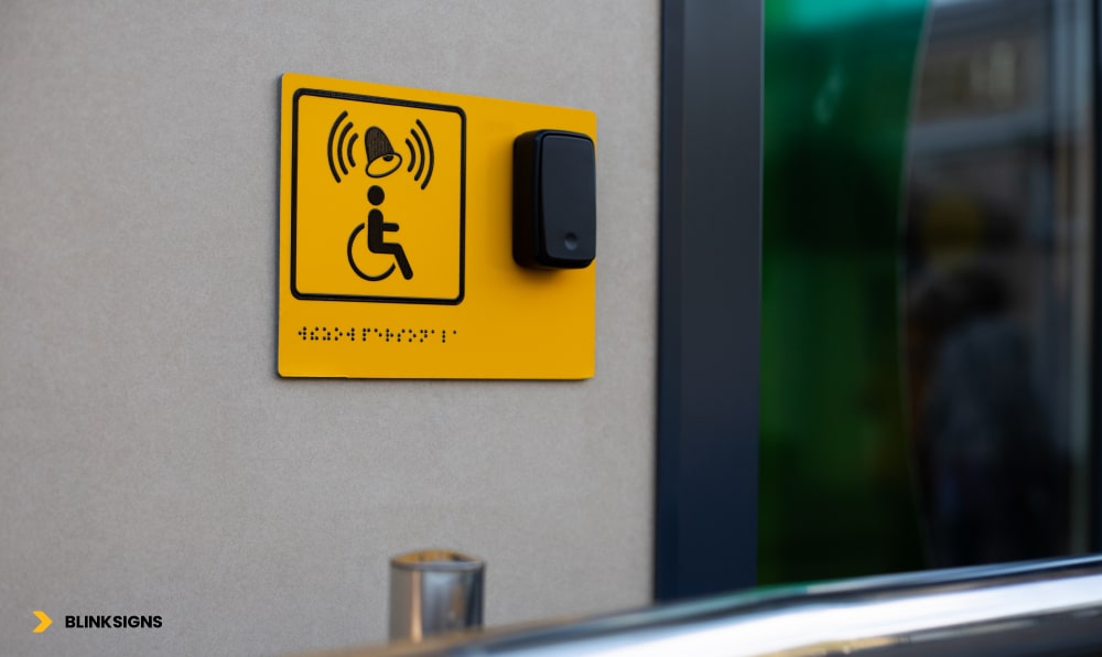 Wayfinding Accessibility: Designing Inclusive Navigation Systems for All Users 5 Disabled person sign with braille text and a panel with a button to call staff for assistance