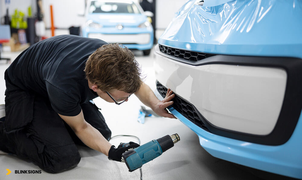 professional installer heating the car wrap for proper installation