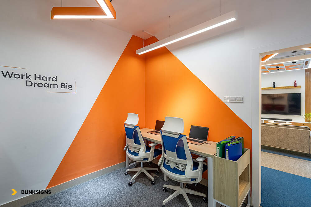 Workplace Environmental Graphics: Boosting Culture, Productivity & Brand Identity 2 office with two good chairs and pcs and with green and white wall graphics that says a quote "work hard dream big"