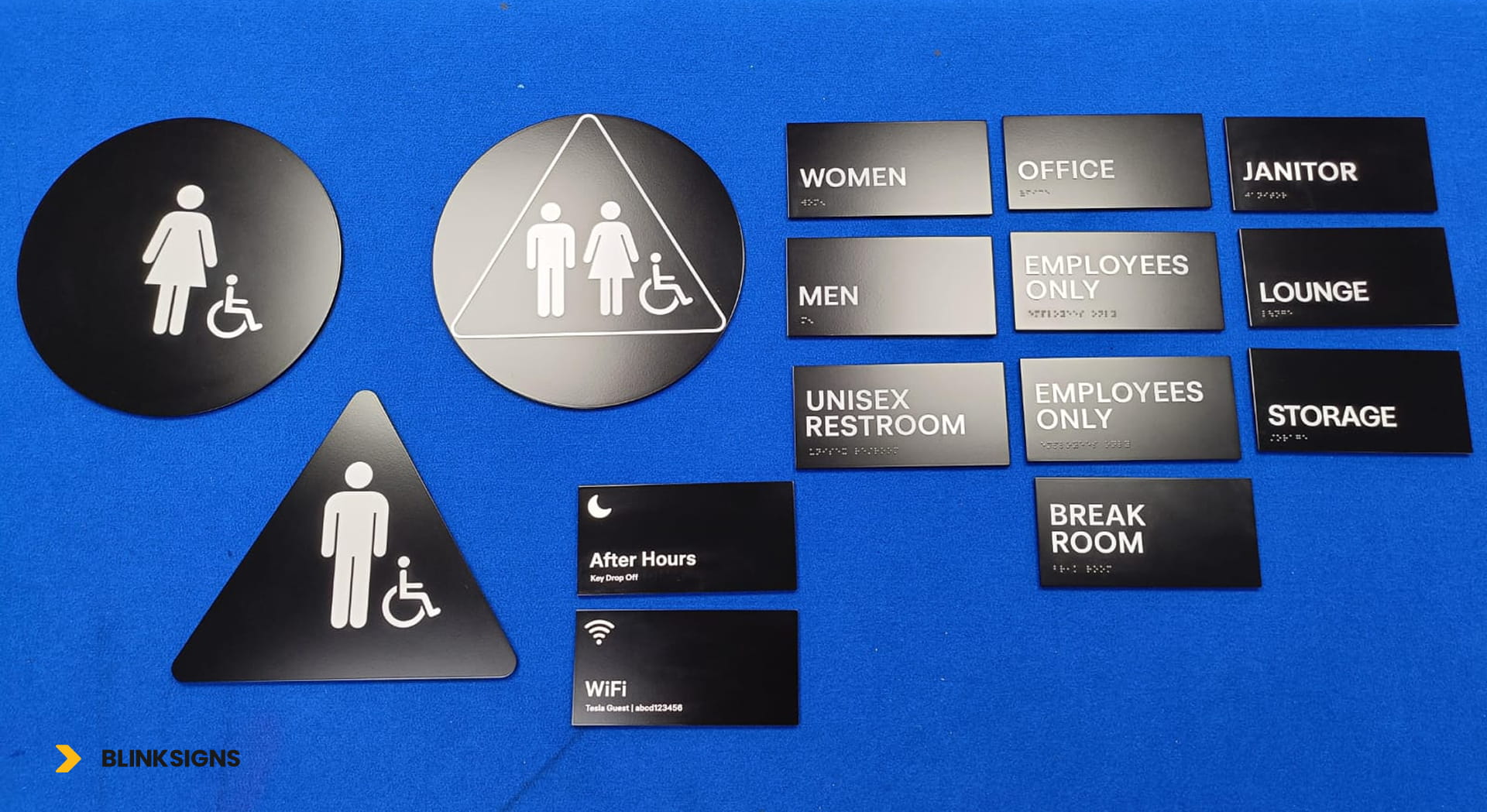 Multiple ADA room signs displayed for the Tesla building in Wesley Chapel, indicating men's, women's, and accessible restrooms.