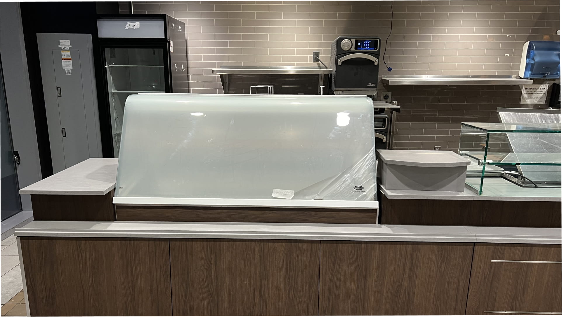 Restaurant service counter featuring 3M Di-Noc PW-2311MT woodgrain finish on lower cabinetry and a white frosted sneeze guard.